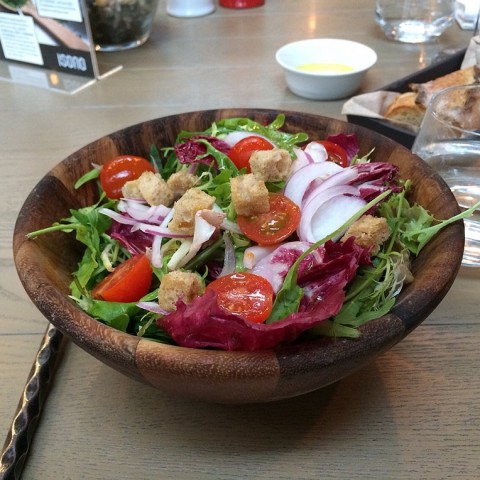 mixed green salad with tomatoes, red onion, croutons, pine nuts